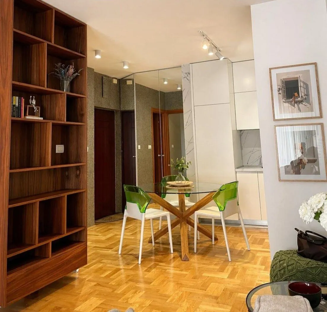 Living room with dining area and wooden bookcase.