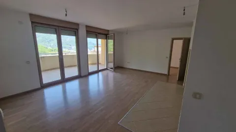 Prazna dnevna soba sa drvenim podom i izlazom na terasu. - image 3