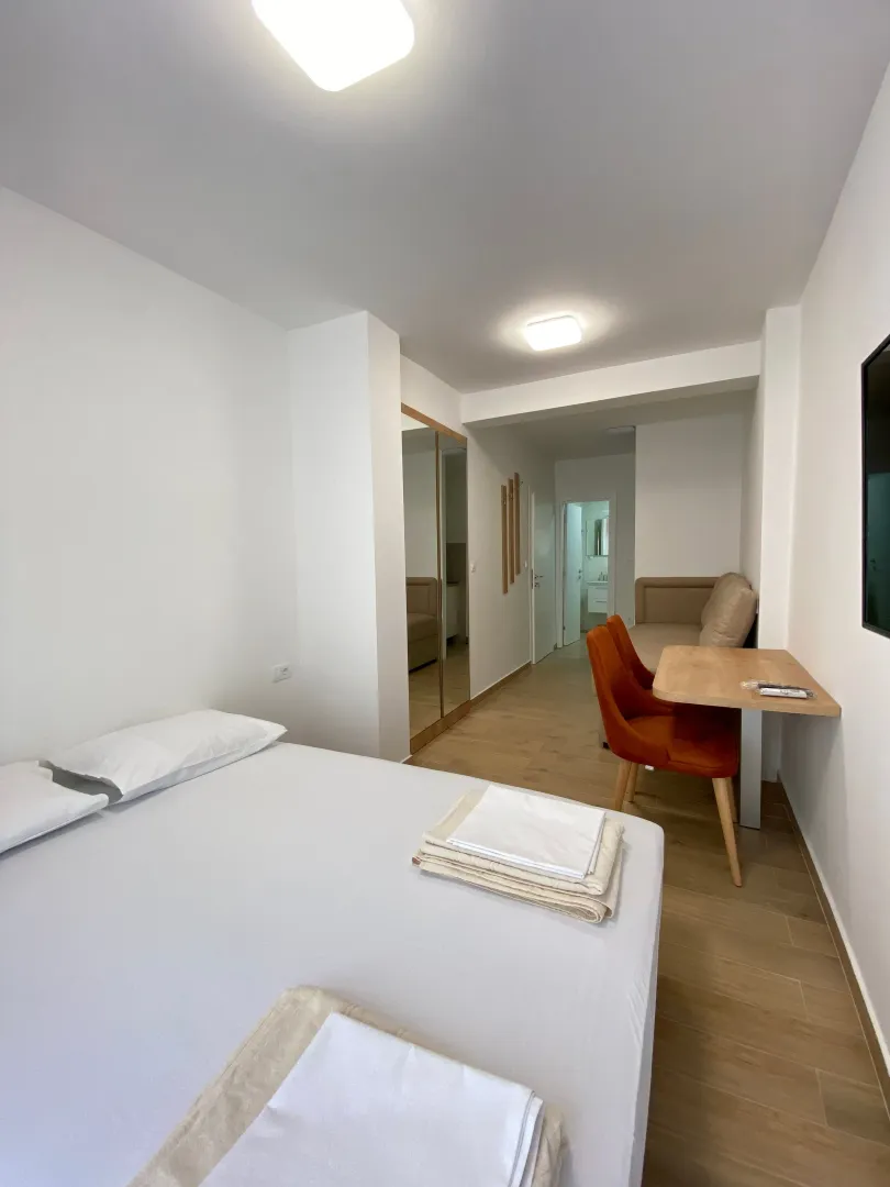 Main bedroom with a double bed, a desk, and a mirrored wardrobe.
