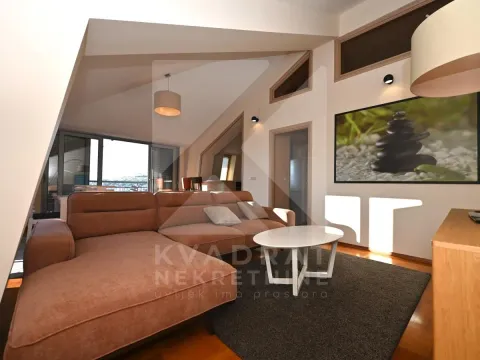 Living room with a sectional sofa, coffee table and sloping ceiling. - image 3