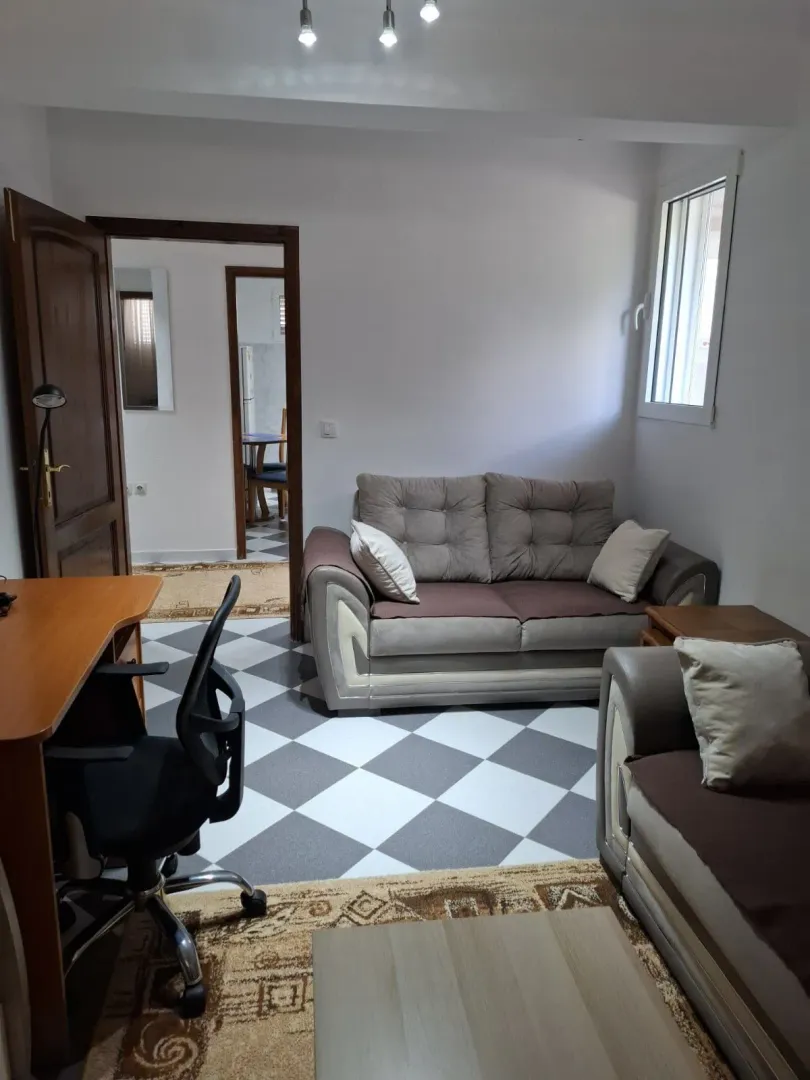 Living room with a sofa set, office desk, and tiled flooring.