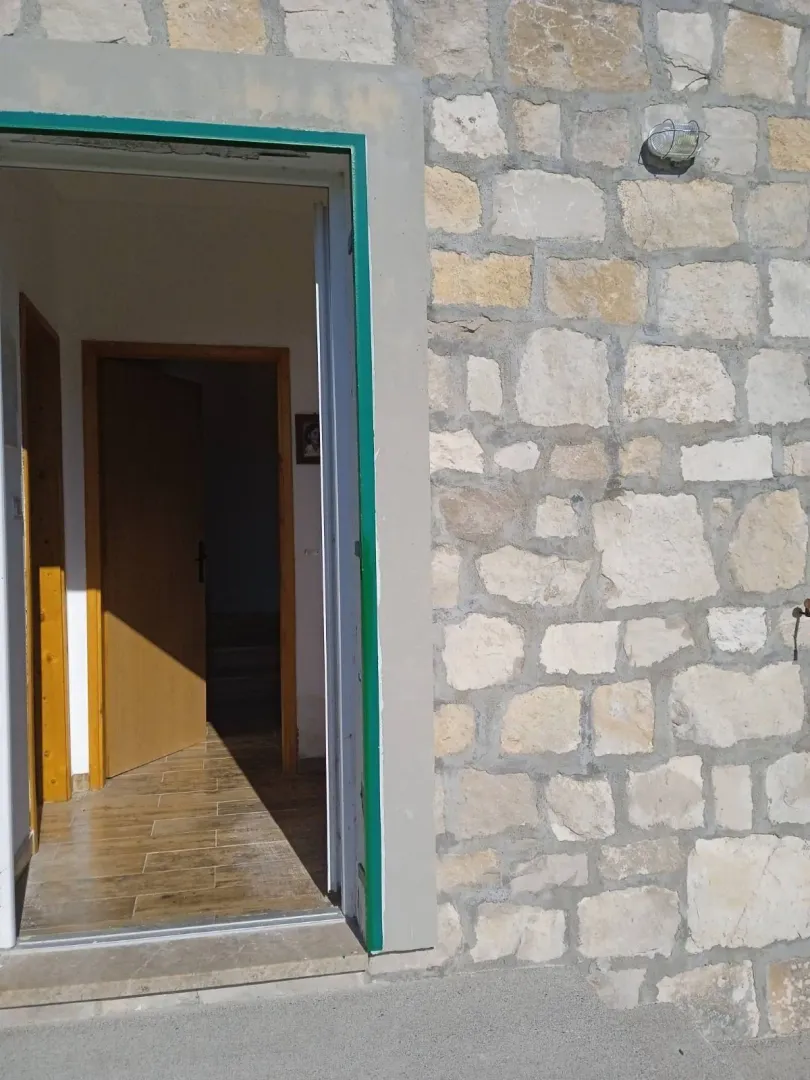 Ulazna vrata kuće sa kamenom fasadom.