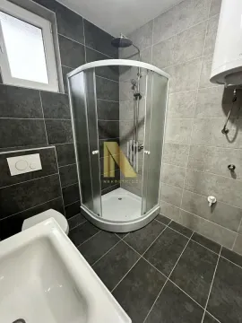 Moderno opremljeno kupatilo sa tuš kabinom i sivim pločicama. - image 7
