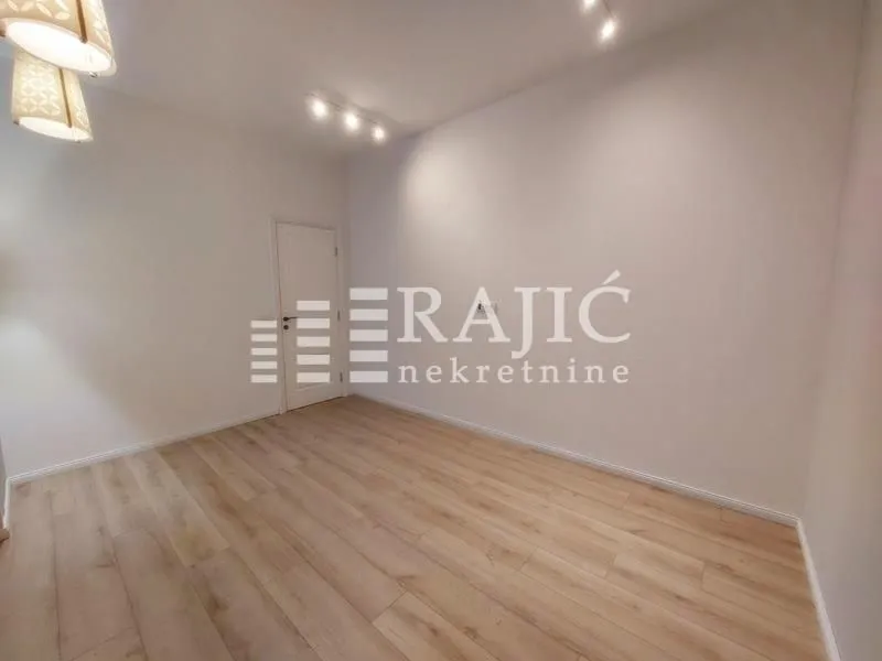 Empty room with laminate flooring and white walls.