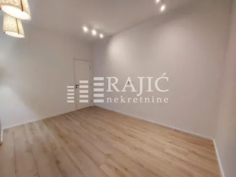 Empty room with laminate flooring and white walls. - image 5