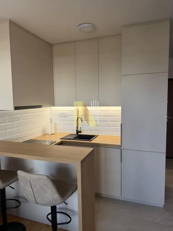 Modern kitchen with light cabinetry, wooden countertops, and a breakfast bar with bar stools.