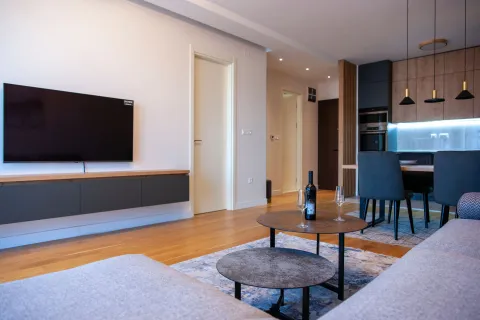 Living room with sofa, TV, and view of the kitchen and dining area. - image 5