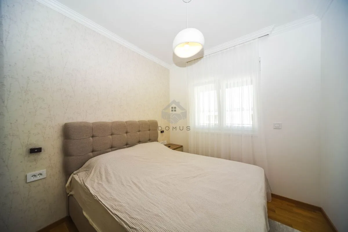 Furnished bedroom with a double bed and a window.