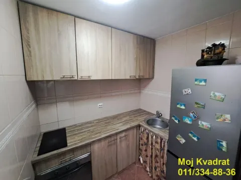 Manja kuhinja sa drvenim elementima, sudoperom, šporetom i frižiderom. - image 3