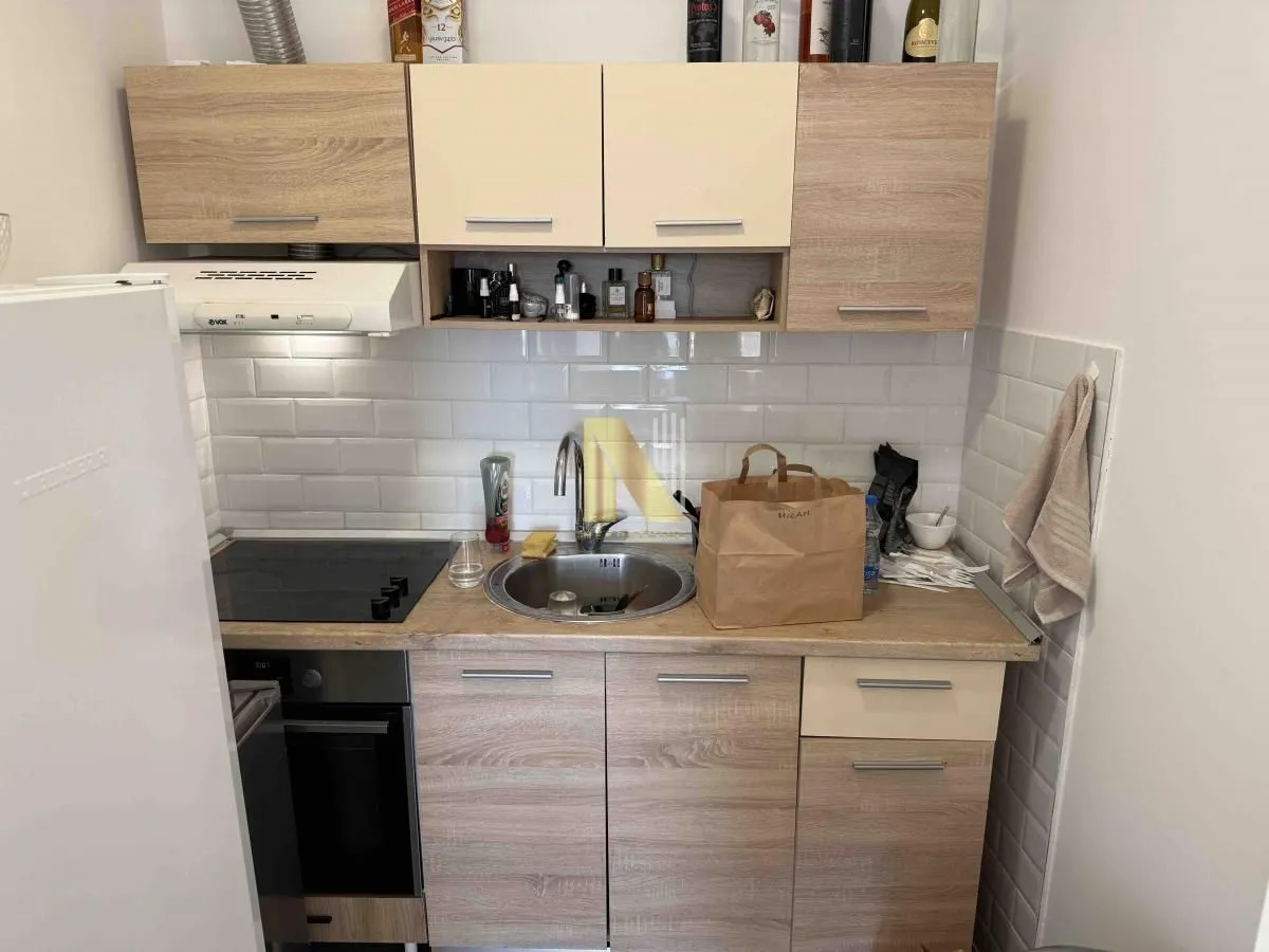 Small kitchen with wooden units, a sink, and a built-in cooktop.