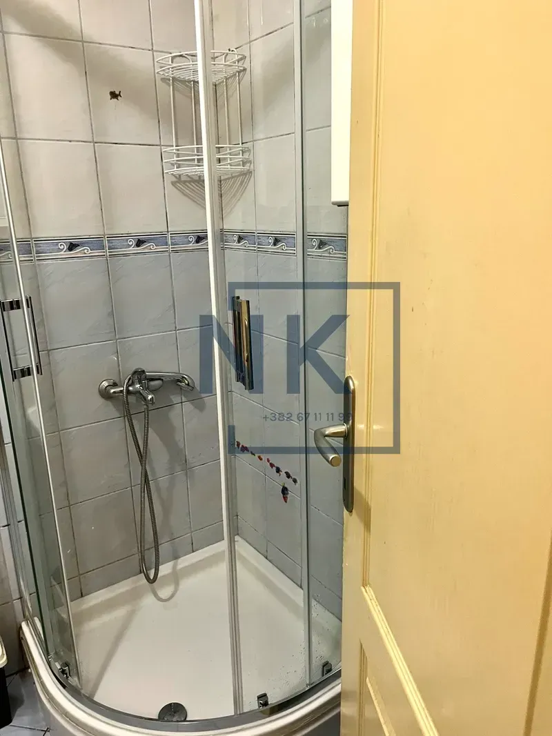 Bathroom with a shower cabin and ceramic tiles.