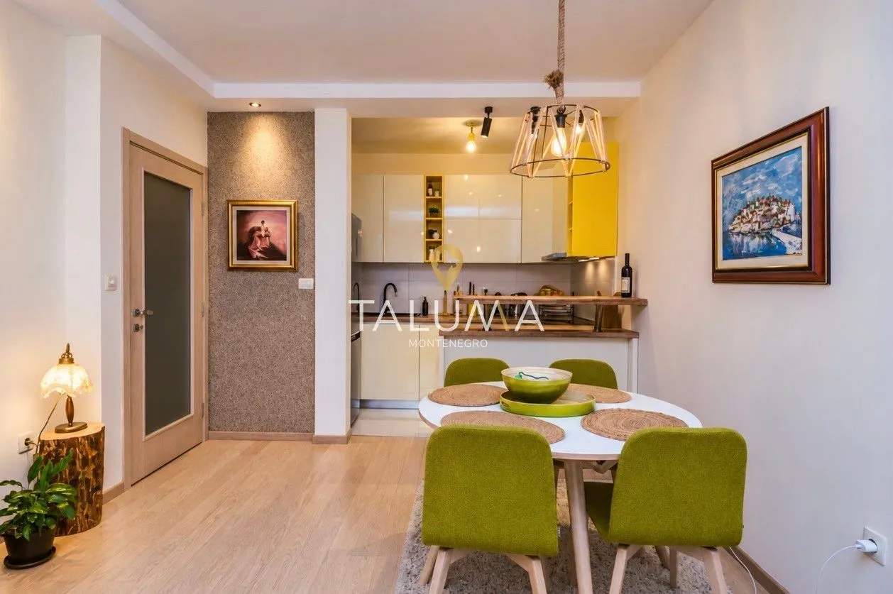 Dining area with a table and green chairs overlooking the kitchen.