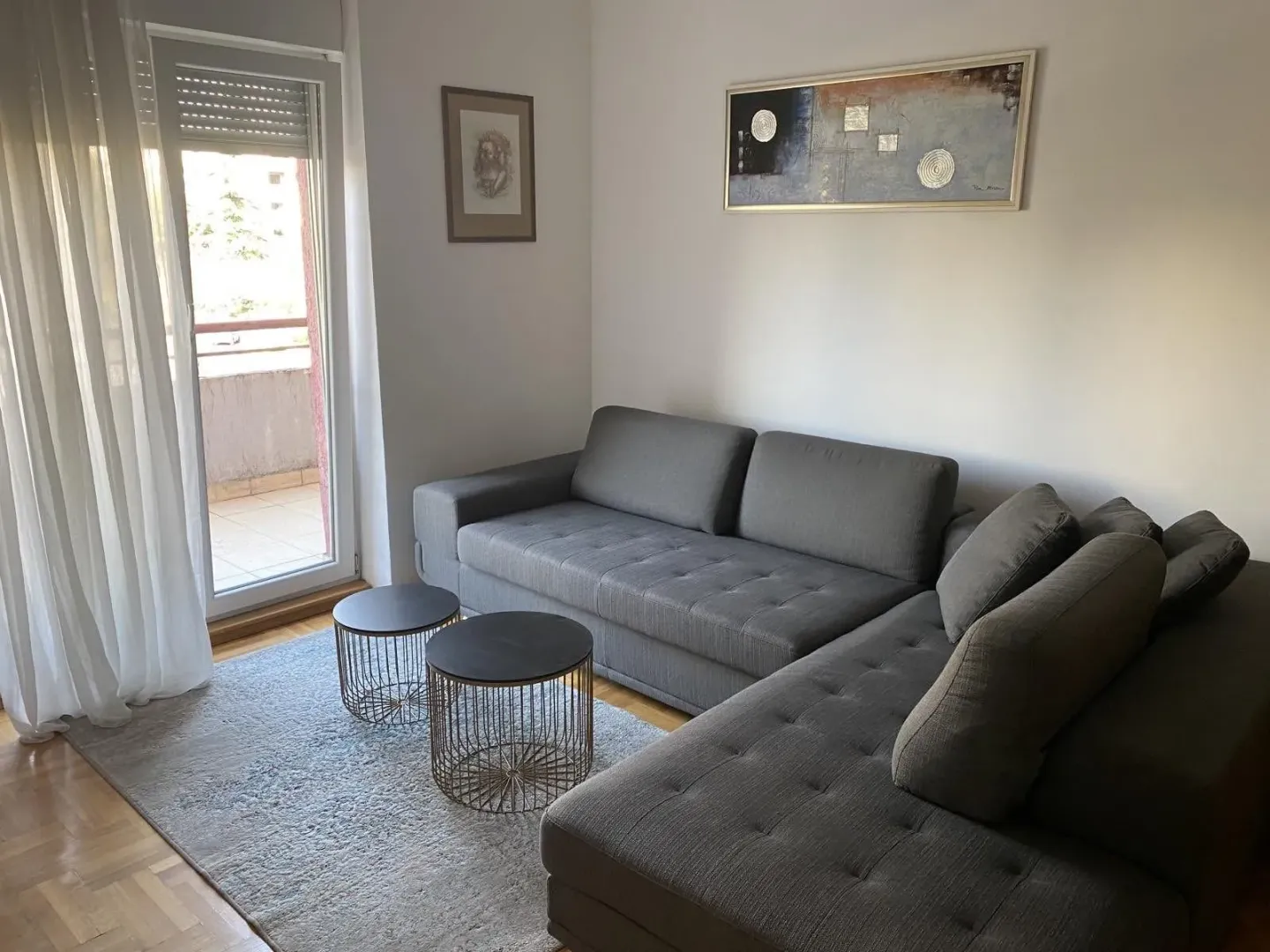 Bright living room with a grey sectional sofa and balcony access.