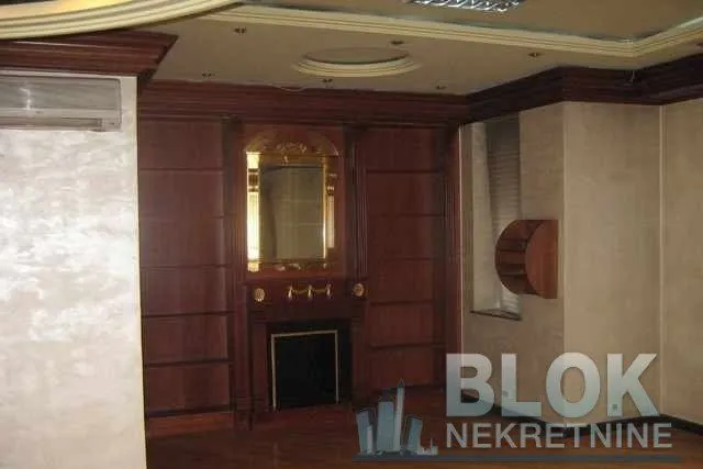 Living room with decorative wood paneling, fireplace, and mirror.
