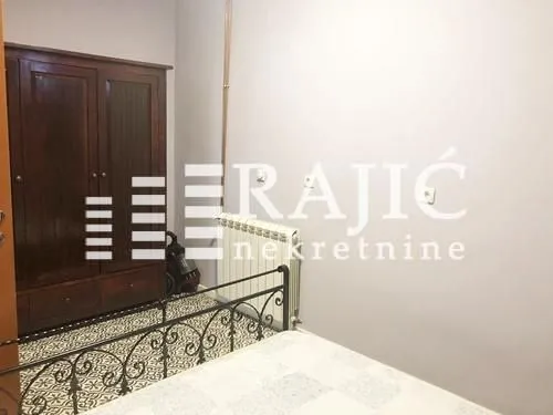 Spavaća soba sa krevetom i drvenim ormanom.