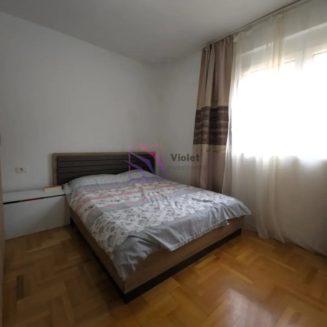Spavaća soba sa bračnim krevetom i prozorom.