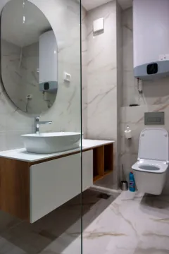 Modern bathroom with a washbasin, mirror, and toilet. - image 12