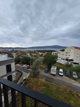 Pogled sa terase na naselje, parking i more u daljini. - image 10