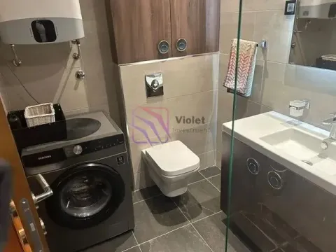 Modern bathroom with a washing machine, wall-hung toilet, and vanity sink. - image 10