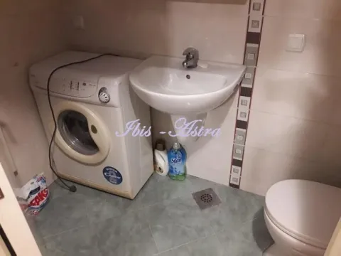Small bathroom with a washbasin, toilet, and washing machine. - image 8