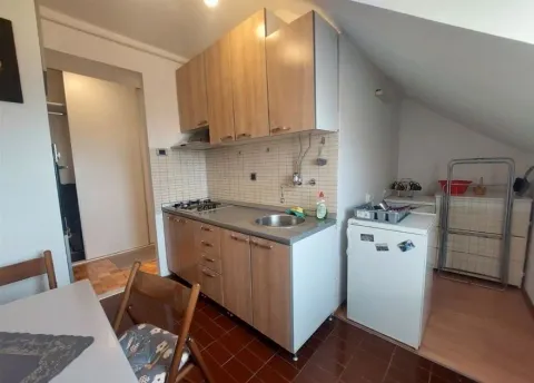 Small kitchen with wooden cabinets in an attic space. - image 6