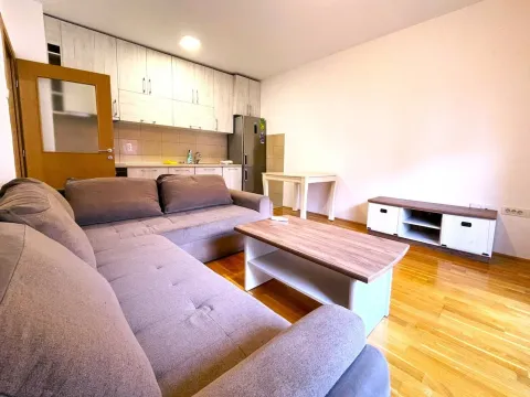 Dnevni boravak sa garniturom, trpezarijskim stolom i kuhinjom u pozadini. - image 2