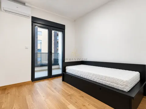 Smaller bedroom with a bed and access to the terrace. - image 10