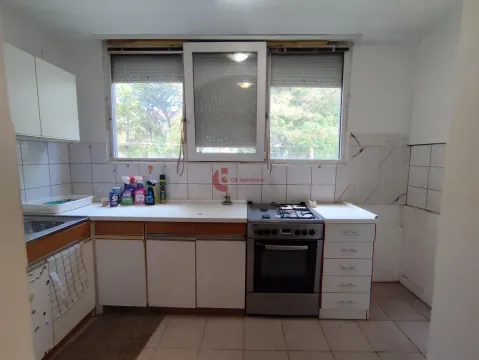 Starija kuhinja sa prozorom iznad sudopere i šporeta. - image 4