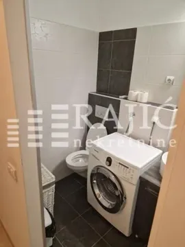 Smaller bathroom with toilet and washing machine. - image 10