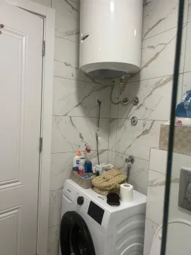 Small bathroom with a washing machine and water heater. - image 10