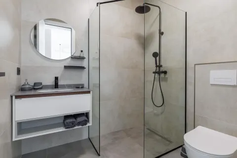 Modern bathroom with a shower cabin, washbasin, and toilet. - image 14