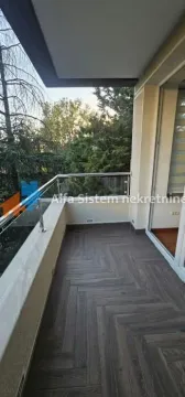 Prostrana natkrivena terasa sa pogledom na zelenilo i staklenom ogradom. - image 3