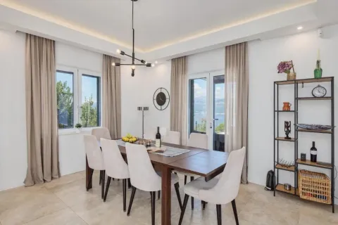 Bright dining room with a large table, chairs, and shelving unit. - image 12