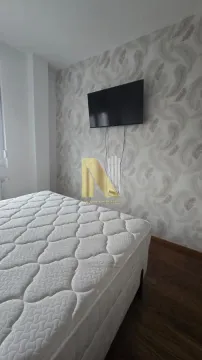 Spavaća soba sa krevetom i televizorom na zidu. - image 9