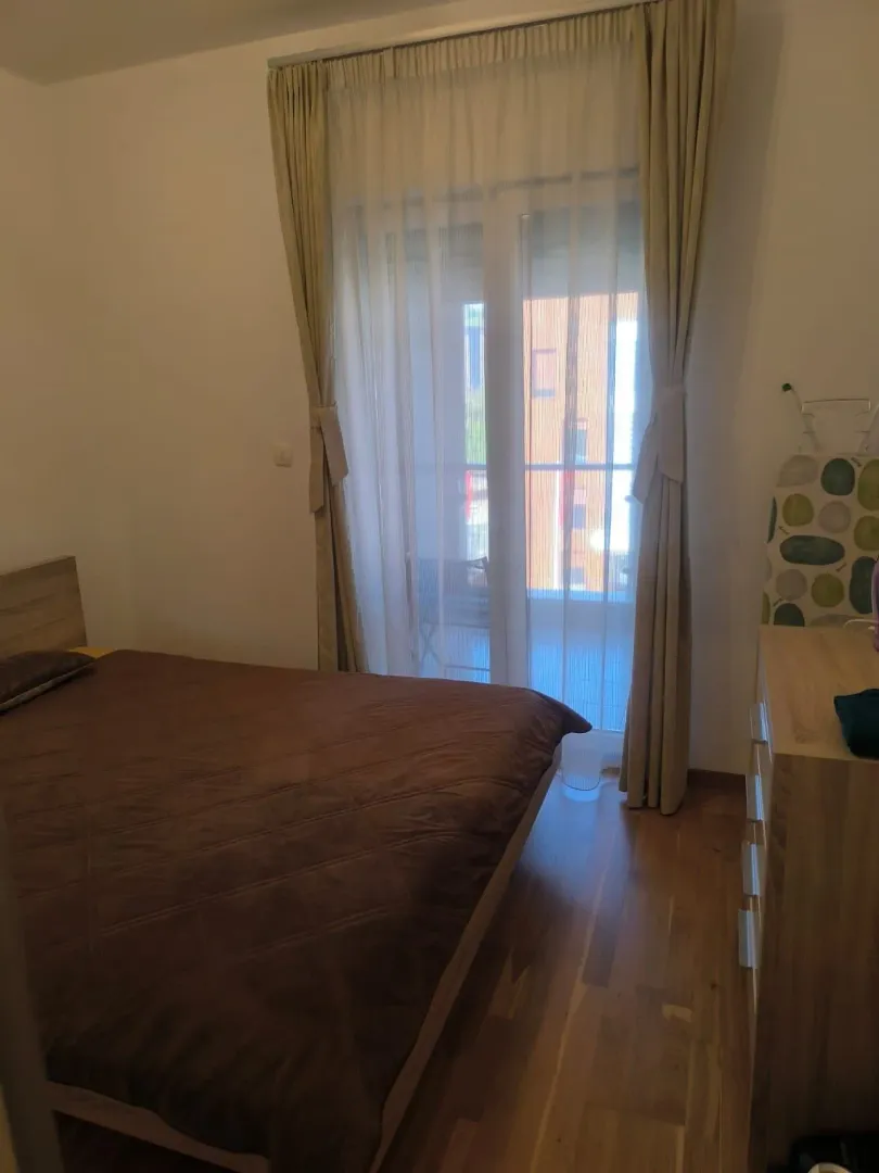 Furnished bedroom with a double bed and a window overlooking the terrace.