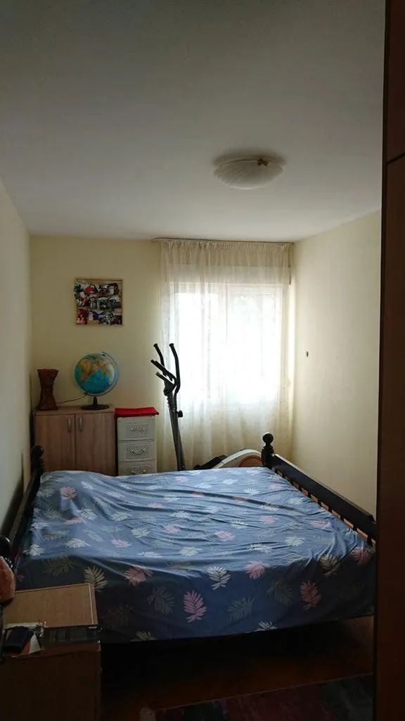 Bedroom with a double bed, a window, and a corner with a globe.