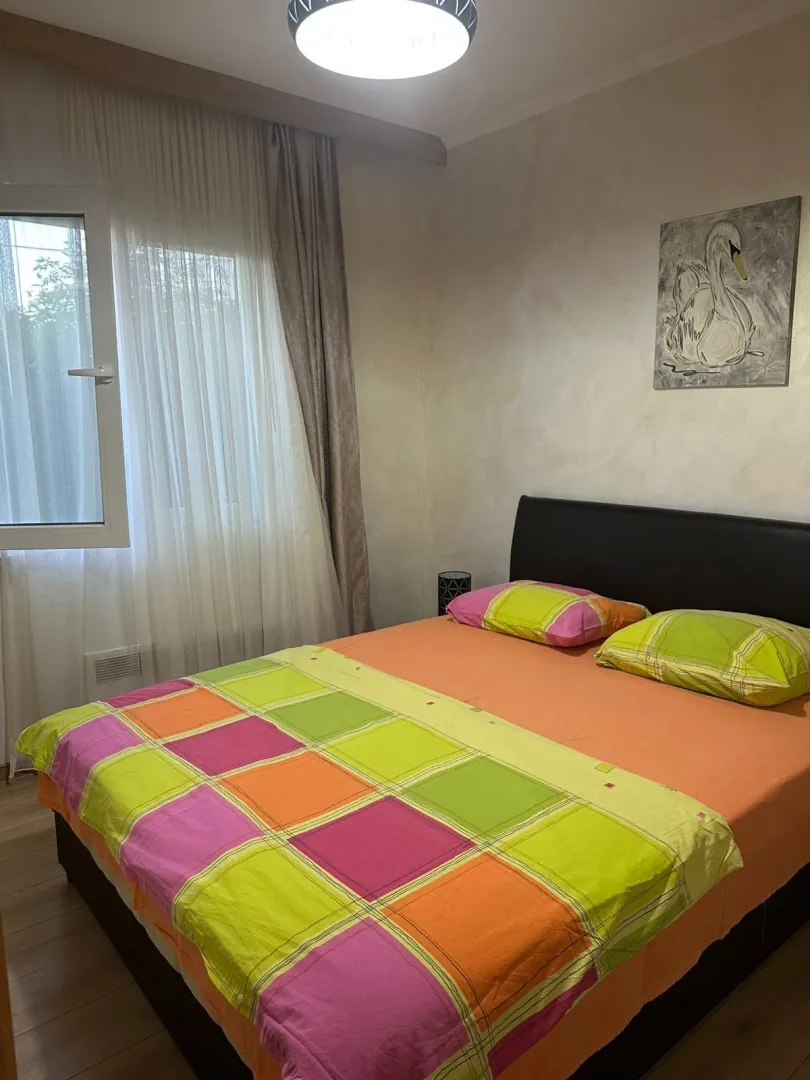 Furnished bedroom with a double bed and a window.