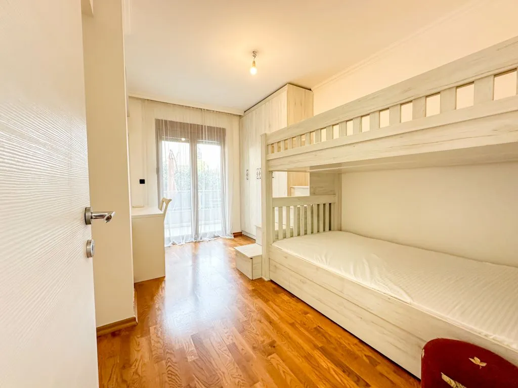 Children's bedroom with a bunk bed, wardrobe, and a desk.