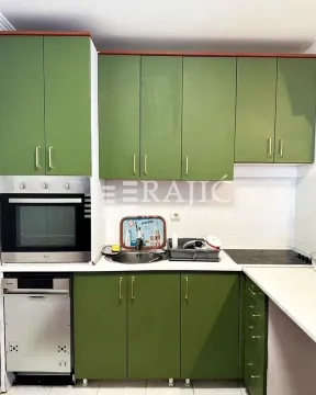 Small kitchen with green cabinets and built-in oven. - image 10