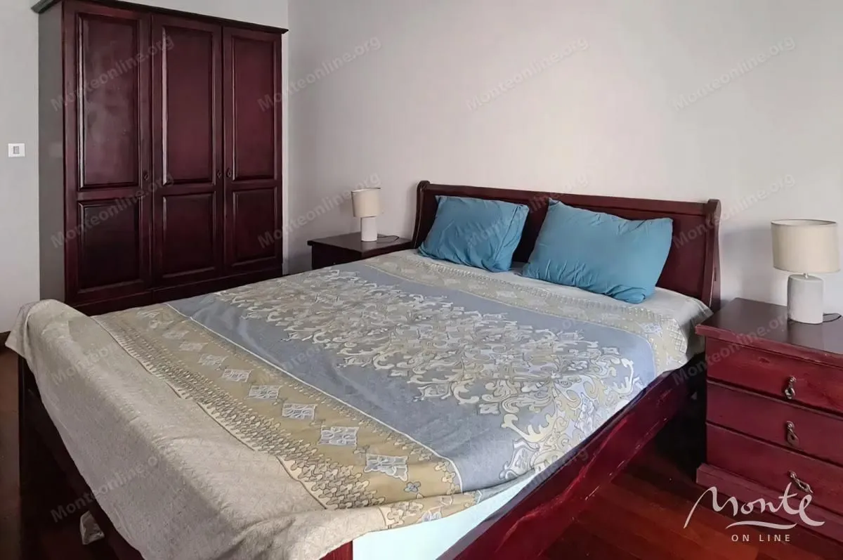 Furnished bedroom with a double bed, wardrobe, and bedside tables.