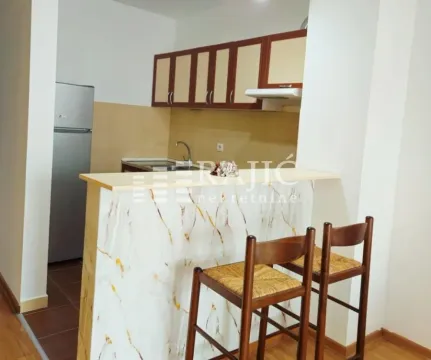 Small kitchen with a bar and wooden chairs. - image 7