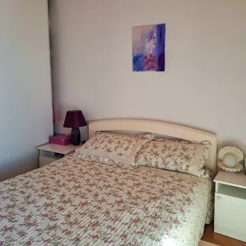 Spavaća soba sa bračnim krevetom, noćnim stočićima i umjetničkom slikom na zidu. - image 21