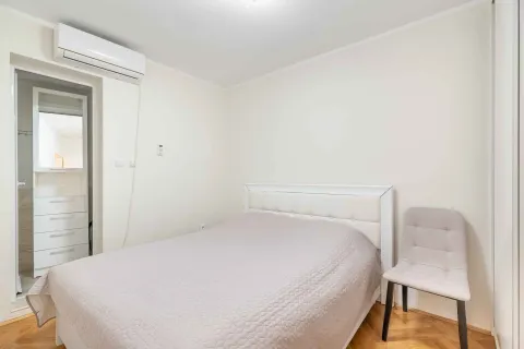 Namještena spavaća soba sa bračnim krevetom, stolicom i klima uređajem. - image 10