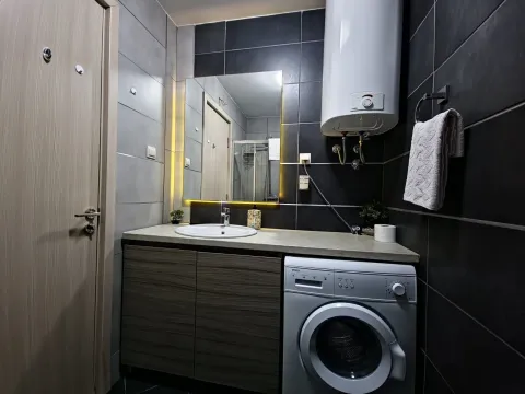 Modern bathroom with a sink, mirror, and washing machine. - image 6