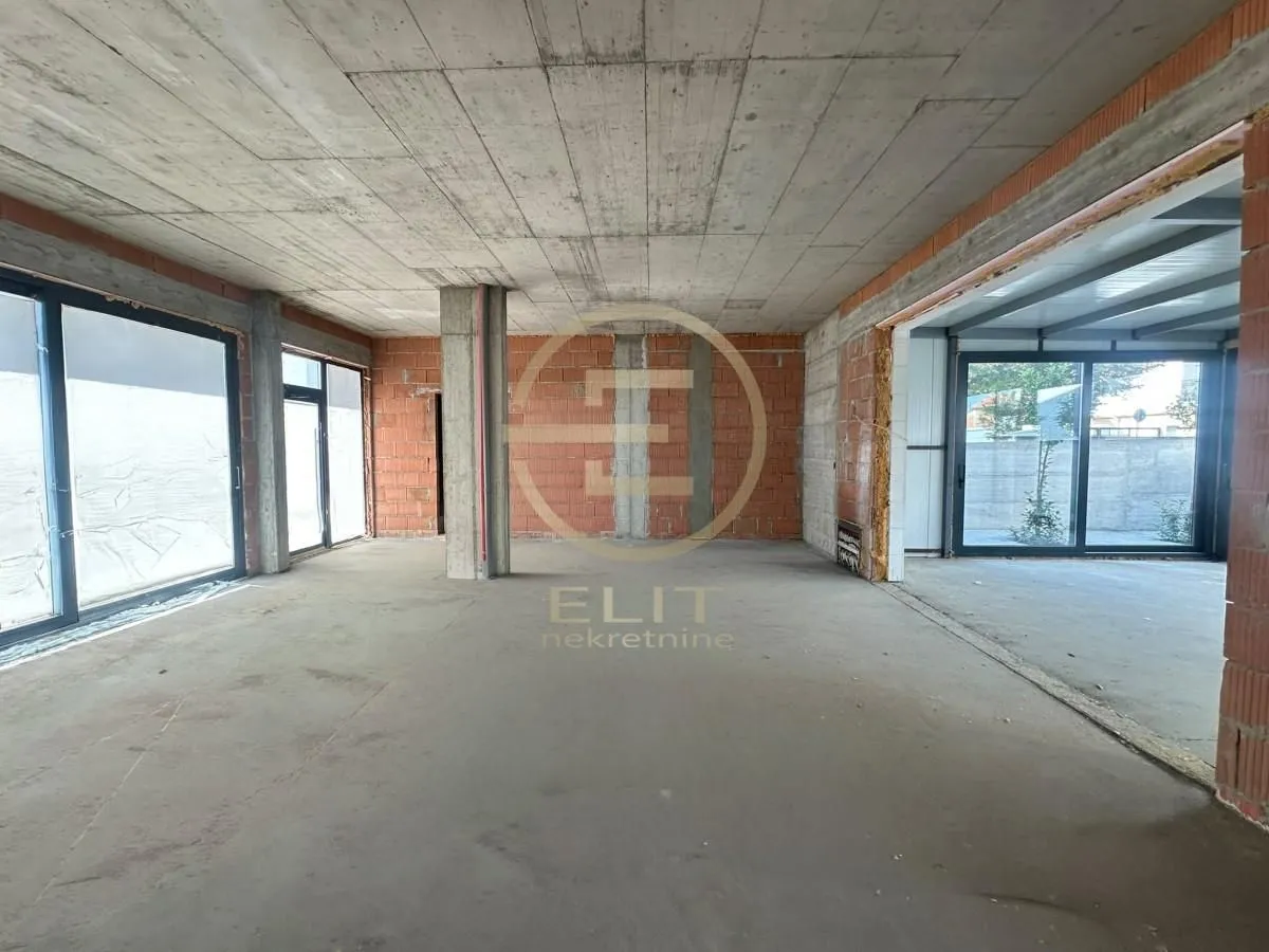 Unfinished bare space in rough construction with concrete ceiling and pillars.