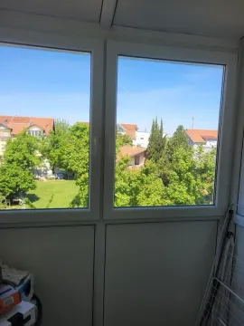 Pogled kroz prozor na okolno zelenilo i zgrade. - image 12