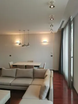 Bright living room with a sectional sofa and a dining table. - image 2