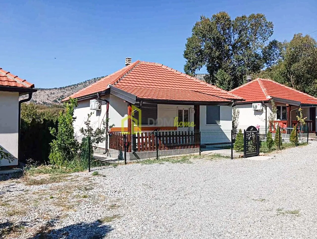 Exterior view of a single-story house with a landscaped yard and fence.
