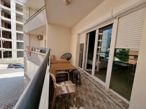 Furnished balcony with a table and chairs and a view of surrounding buildings. - image 10