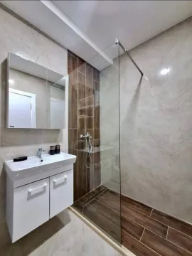Modern bathroom equipped with a walk-in shower and vanity unit. - image 6